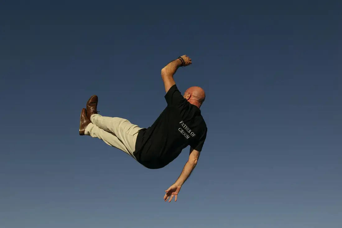 A guest lifted into the air against a clear blue sky during the celebration