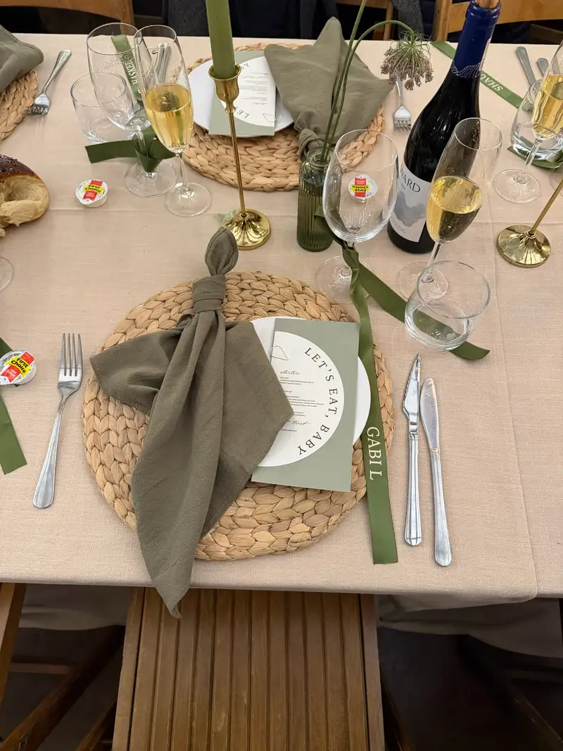Printed menu and olive napkin on a woven placemat with a ribbon name tag
