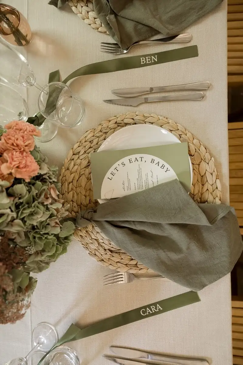 Two place settings with named ribbon tags and printed menus on woven placemats